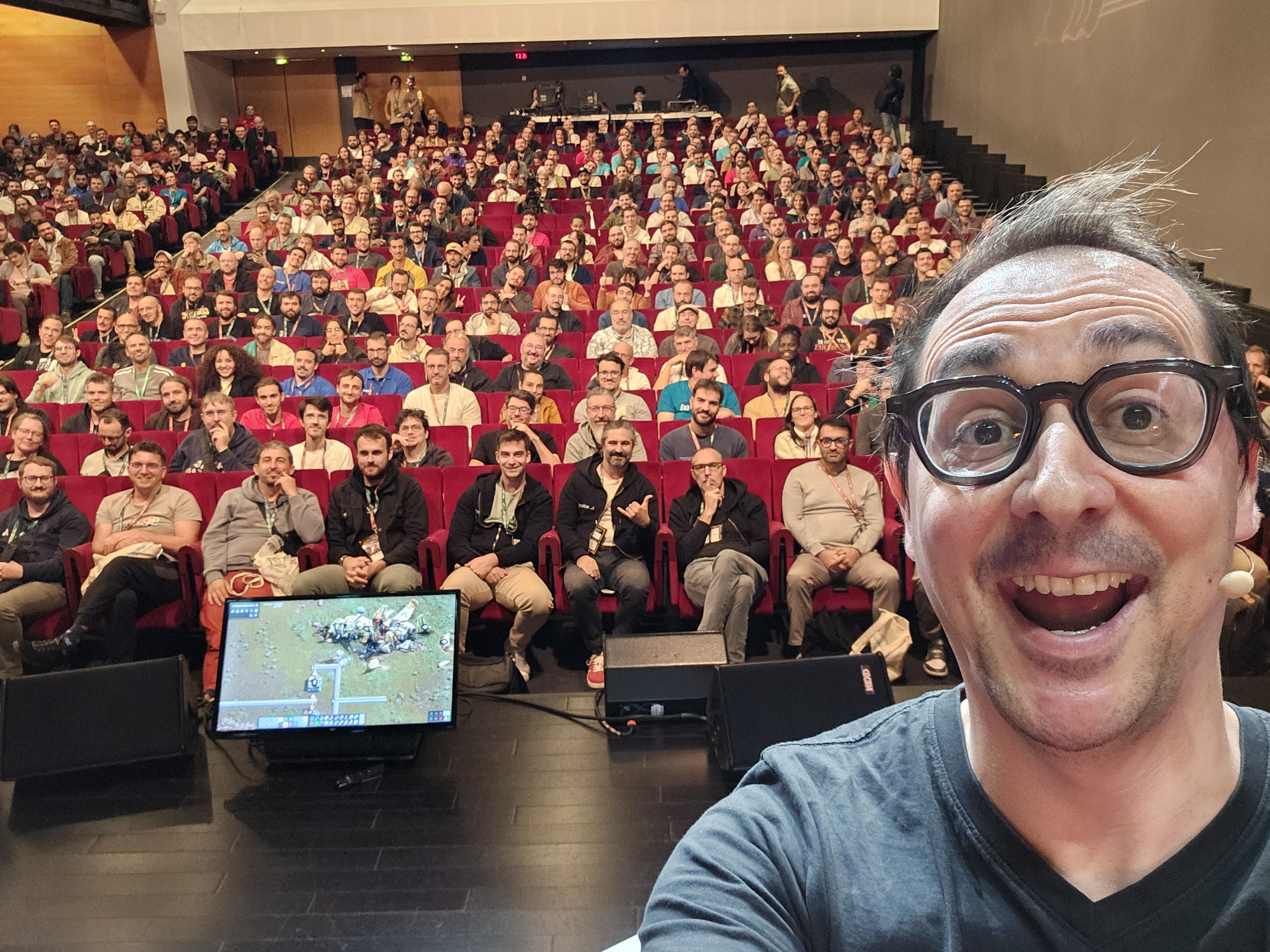 Selfie de moi sur scène, la salle pleine en arrière plan 