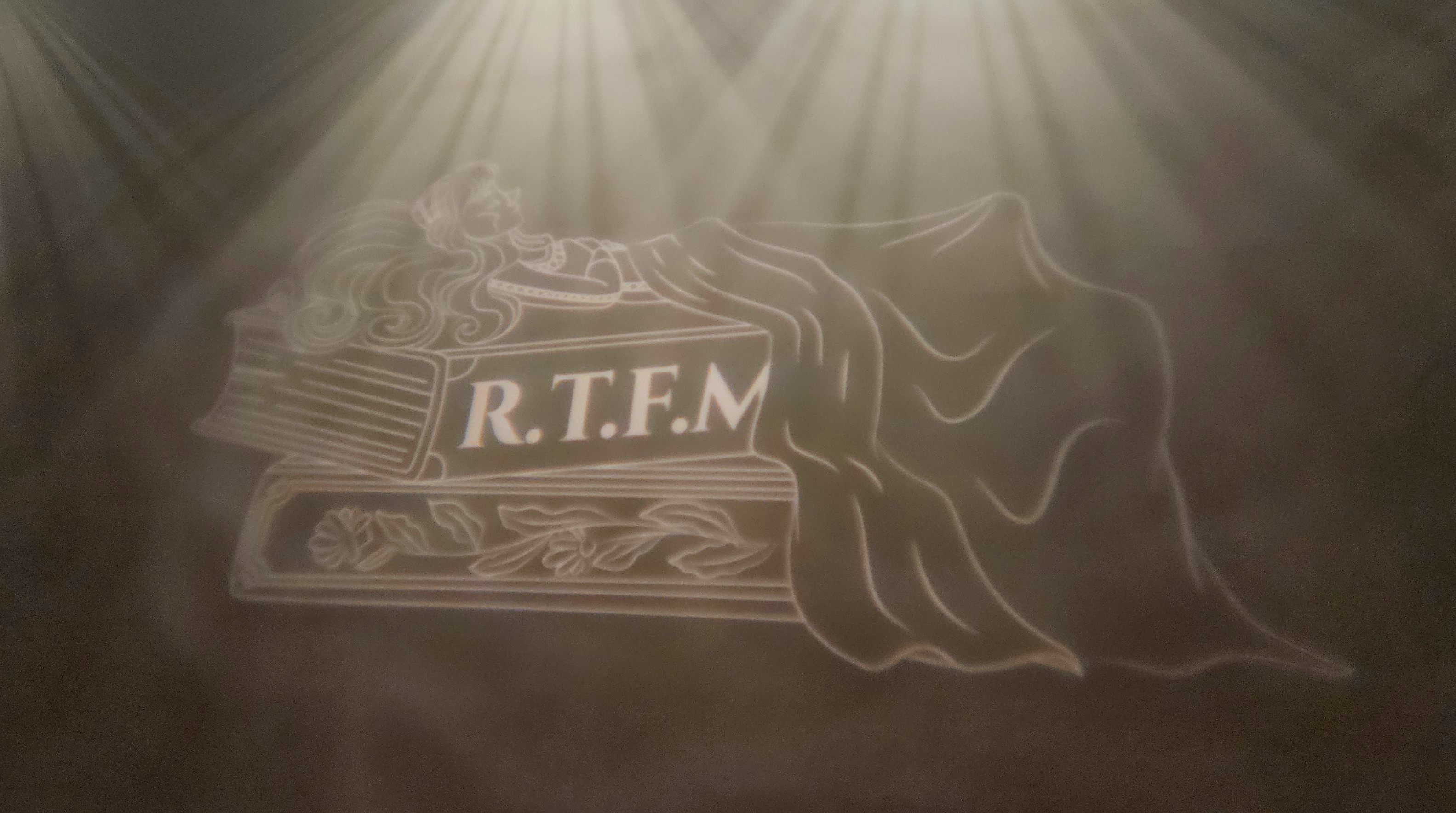 Photo du mur d’une des sales de conférence. Un livre dont la couverture indique ‘RTFM’