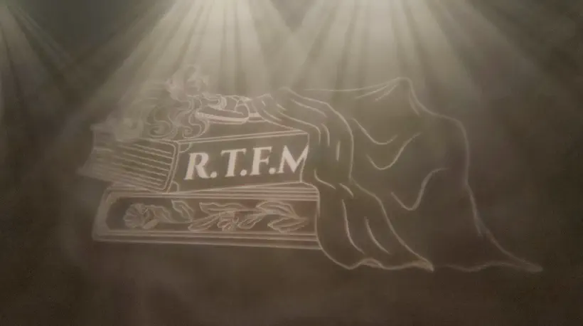 Photo du mur d’une des sales de conférence. Un livre dont la couverture indique ‘RTFM’